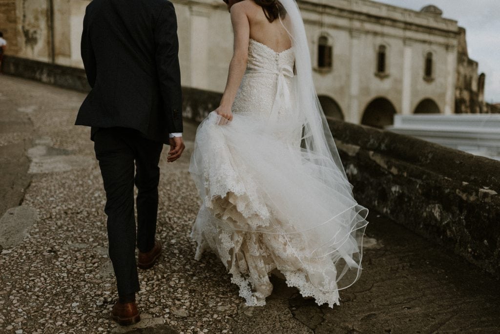 bride and groom walking up cobblestone street