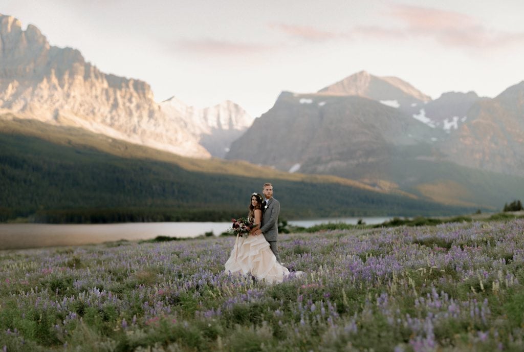 bride and groom standing in a flower field